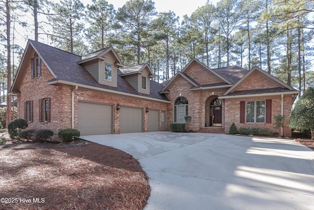 view of front of property with a shingled roof, concrete driveway, brick siding, and an attached garage