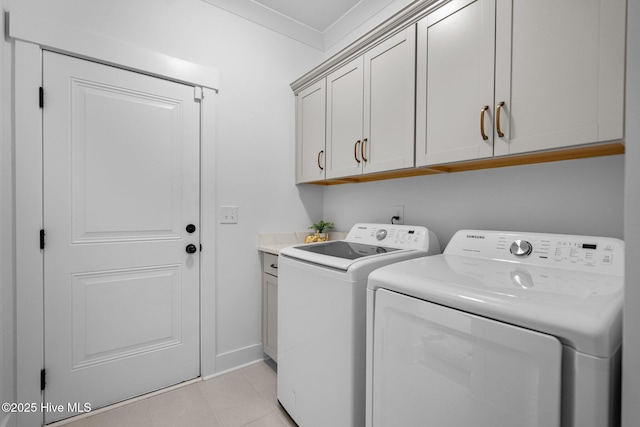 laundry room featuring light tile patterned flooring, cabinets, ornamental molding, and separate washer and dryer