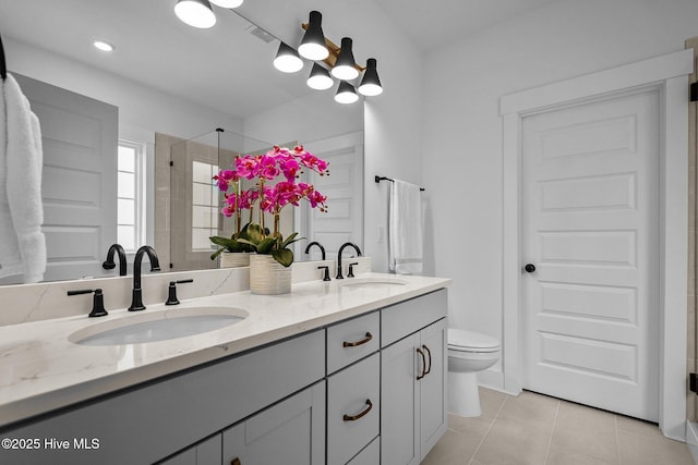 bathroom with tile patterned flooring, vanity, toilet, and walk in shower