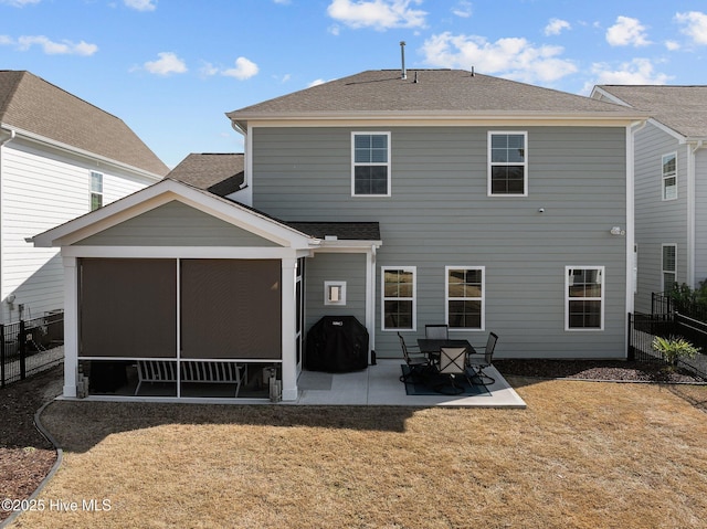 rear view of house with a yard, a patio area, and a sunroom