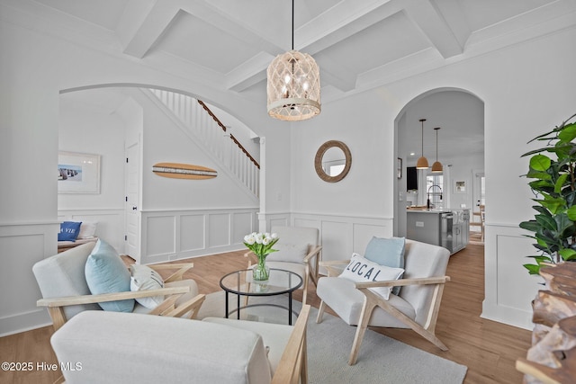 living room featuring hardwood / wood-style floors, a notable chandelier, and beamed ceiling