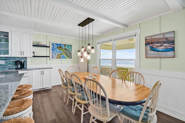 dining area featuring beamed ceiling, dark wood-type flooring, and a notable chandelier