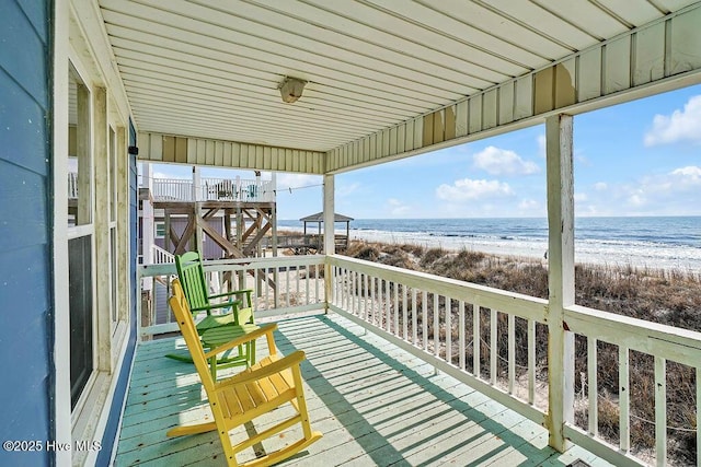 deck featuring a water view and a view of the beach