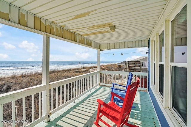 wooden deck with a view of the beach and a water view