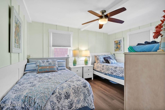 bedroom with dark wood-style floors, a ceiling fan, and a decorative wall