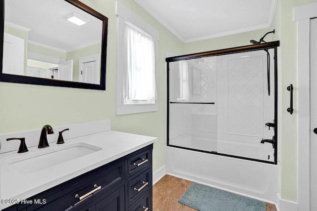 bathroom featuring bath / shower combo with glass door, vanity, baseboards, and ornamental molding