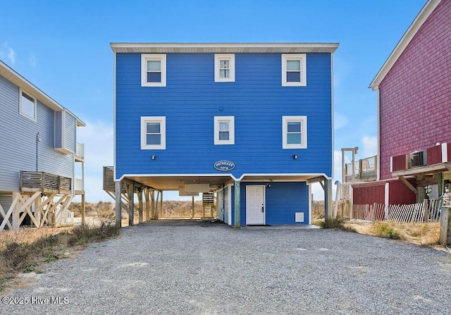 view of front of home with a carport and gravel driveway