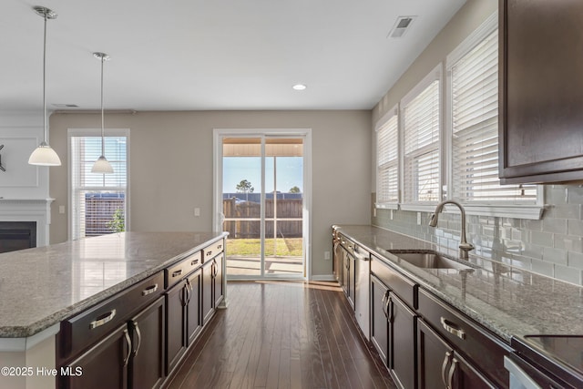 kitchen with dark wood-style floors, visible vents, backsplash, a sink, and dark brown cabinetry