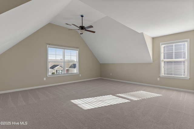 additional living space with carpet floors, ceiling fan, baseboards, and vaulted ceiling