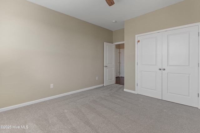 unfurnished bedroom featuring carpet, a closet, ceiling fan, and baseboards