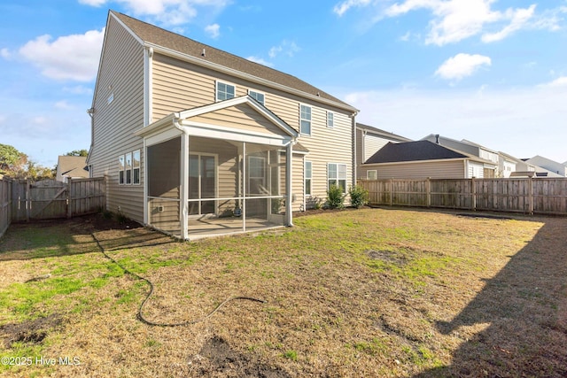 back of house featuring a yard, a fenced backyard, and a sunroom