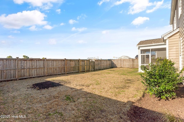 view of yard featuring a fenced backyard and a sunroom