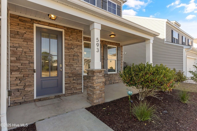 entrance to property featuring stone siding and a porch