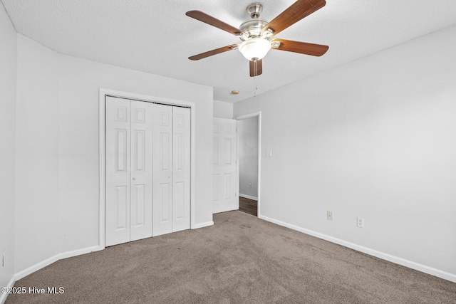 unfurnished bedroom featuring ceiling fan, carpet, a textured ceiling, and a closet