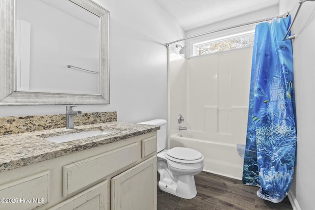 full bathroom featuring toilet, a textured ceiling, hardwood / wood-style floors, shower / tub combo with curtain, and vanity