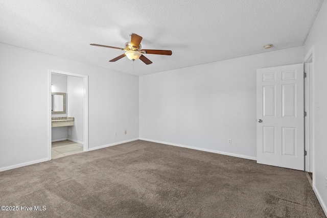 unfurnished bedroom with light carpet, ensuite bathroom, ceiling fan, and a textured ceiling