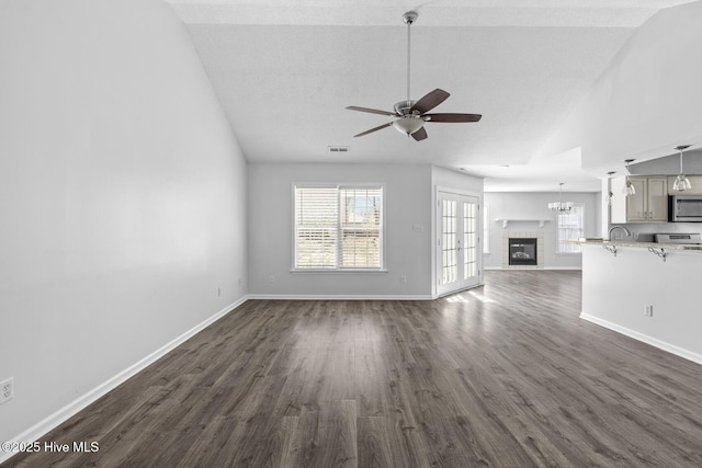 unfurnished living room featuring ceiling fan, dark hardwood / wood-style floors, and lofted ceiling