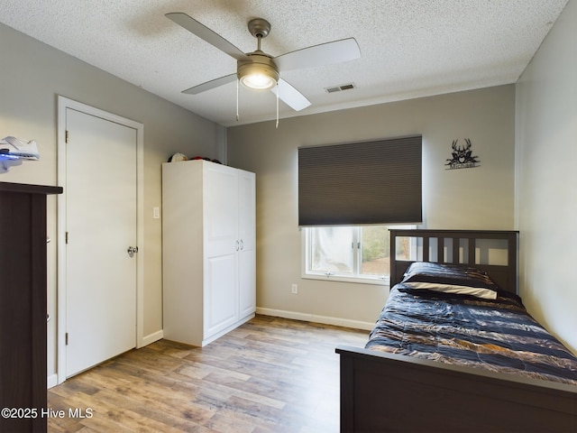 unfurnished bedroom with ceiling fan, a textured ceiling, and light hardwood / wood-style floors