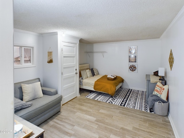 bedroom featuring ornamental molding, a textured ceiling, and light wood-type flooring