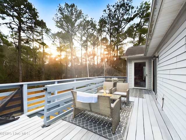 deck at dusk featuring outdoor lounge area