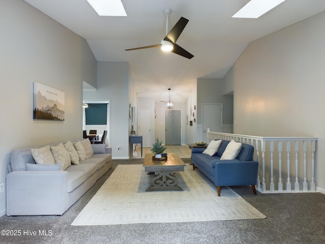 carpeted living room featuring ceiling fan, a skylight, and high vaulted ceiling