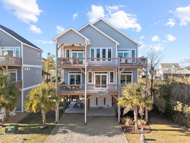 back of property with a carport, a balcony, and ceiling fan