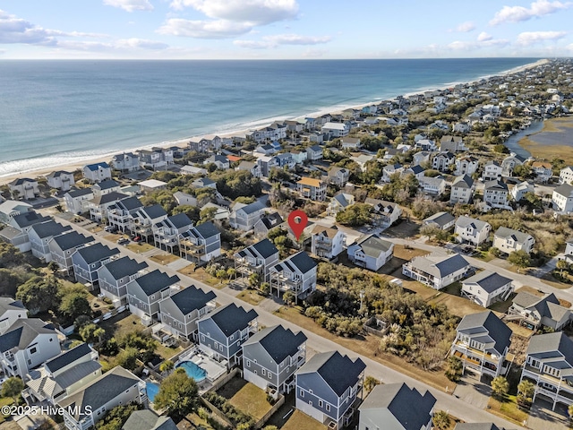 birds eye view of property with a water view and a beach view