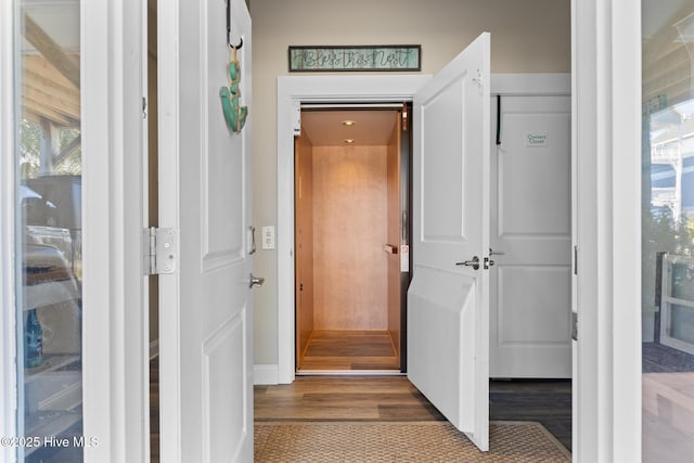 hallway with hardwood / wood-style floors