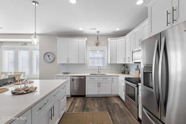 kitchen with white cabinetry, appliances with stainless steel finishes, and pendant lighting