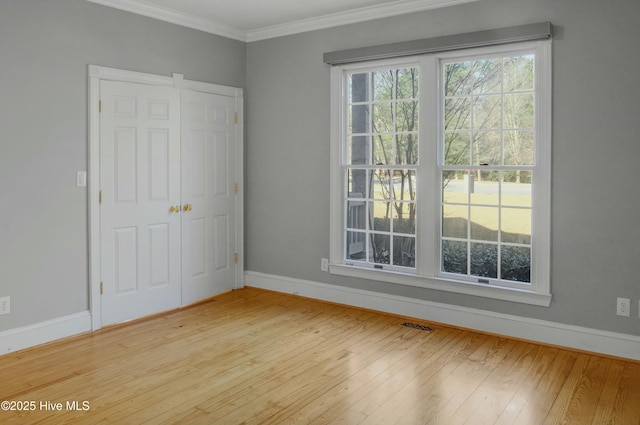 unfurnished bedroom featuring ornamental molding and light hardwood / wood-style floors