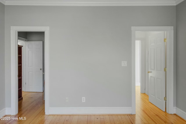 spare room featuring crown molding and light hardwood / wood-style flooring