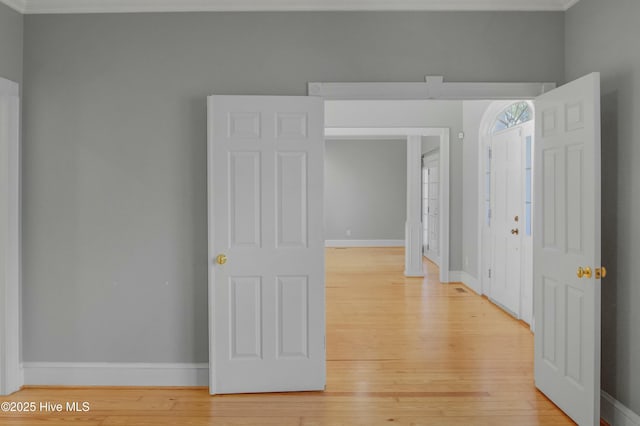 interior space with crown molding and light hardwood / wood-style flooring