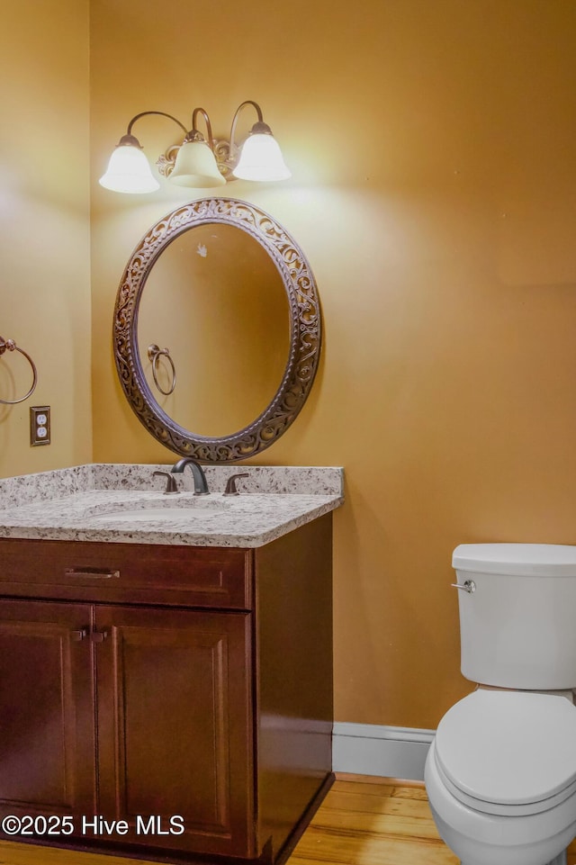 bathroom featuring vanity, hardwood / wood-style floors, and toilet