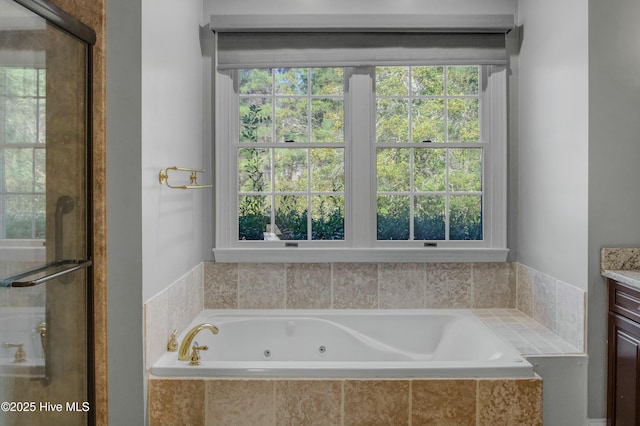 bathroom with vanity and tiled bath