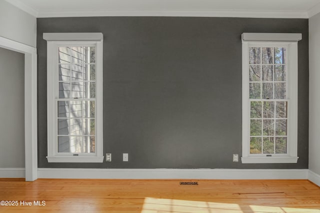 unfurnished room featuring crown molding and wood-type flooring