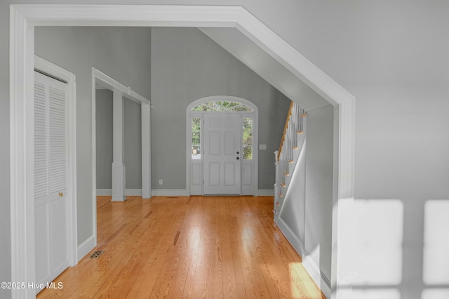 entrance foyer with lofted ceiling and light hardwood / wood-style flooring