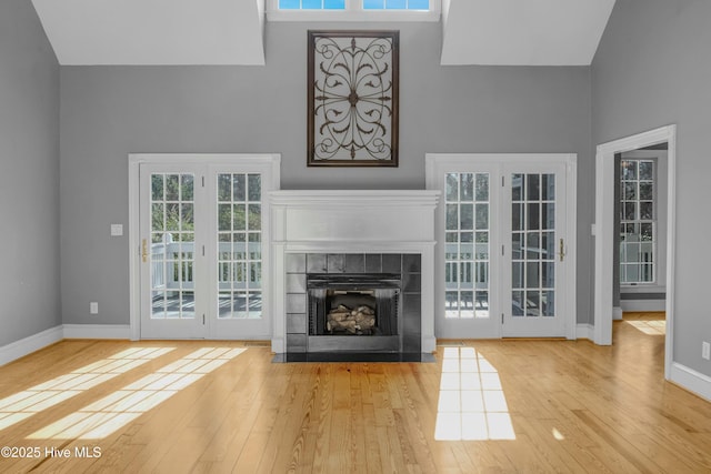 unfurnished living room with a high ceiling and light wood-type flooring