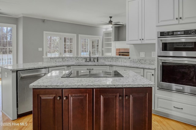 kitchen with white cabinetry, sink, stainless steel appliances, and a kitchen island