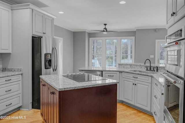 kitchen with sink, crown molding, stainless steel appliances, white cabinets, and kitchen peninsula