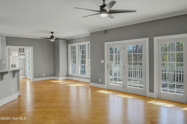 unfurnished living room with crown molding, ceiling fan, and light wood-type flooring