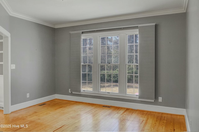 empty room with crown molding and wood-type flooring