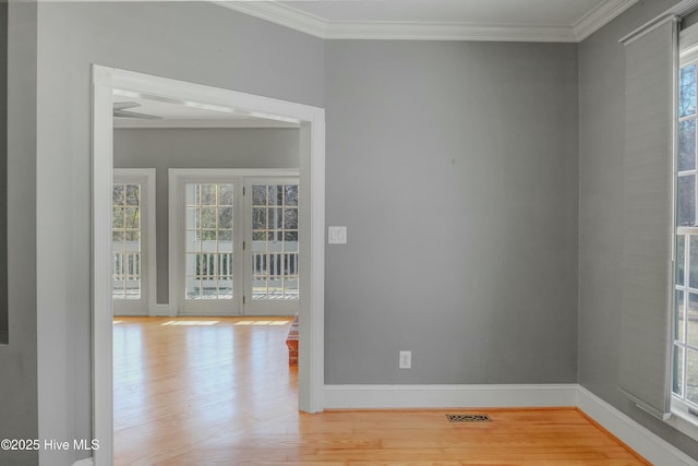 empty room featuring crown molding and light hardwood / wood-style flooring