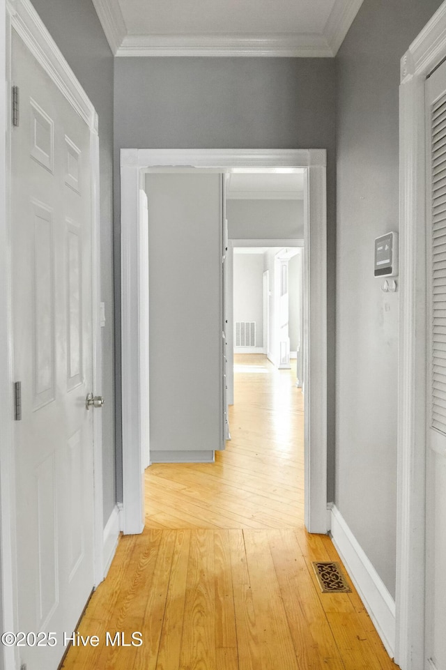 corridor featuring crown molding and light hardwood / wood-style flooring