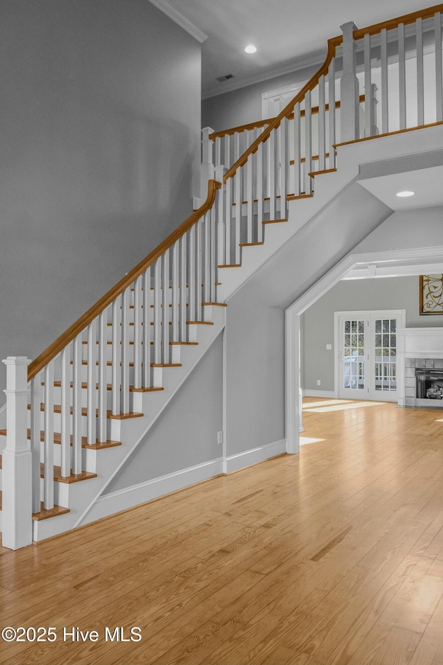 stairs featuring hardwood / wood-style flooring and crown molding