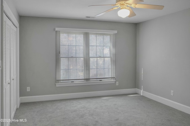 spare room featuring light carpet and ceiling fan