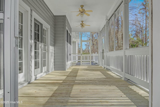 unfurnished sunroom with ceiling fan