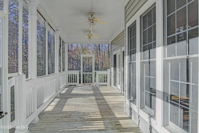 unfurnished sunroom featuring ceiling fan