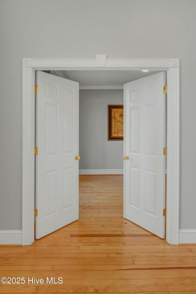 corridor with crown molding and wood-type flooring