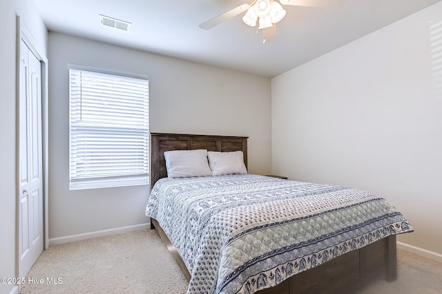 carpeted bedroom with multiple windows, ceiling fan, and a closet