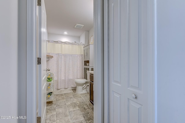 bathroom with a shower with curtain and toilet